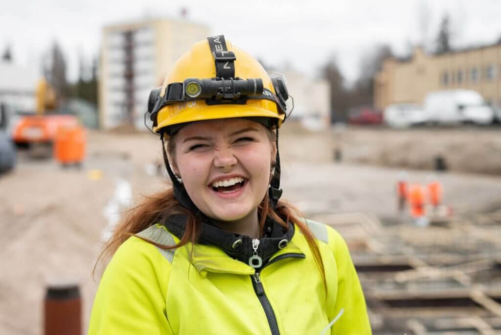 WorkPowerin iloinen kesätyöntekijä rakennustyömaalla.